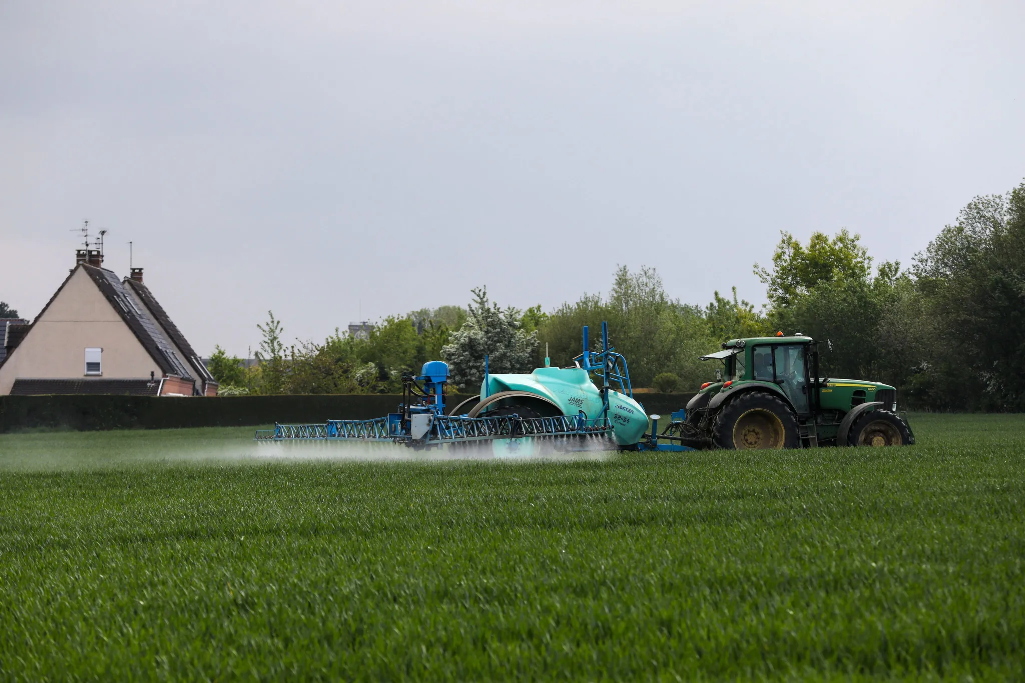 Un agriculteur pulvérise des pesticides sur les cultures d'un champ proche d'habitations, à Roncq, dans le Nord.